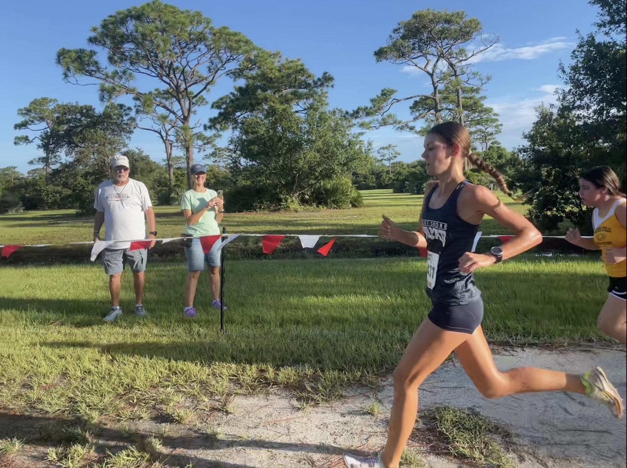 Eyes on the finish line, freshman Elliana Falls sprints the final stretch of the Wickham Jamboree, the first 5K of the cross-country season on Aug. 24.